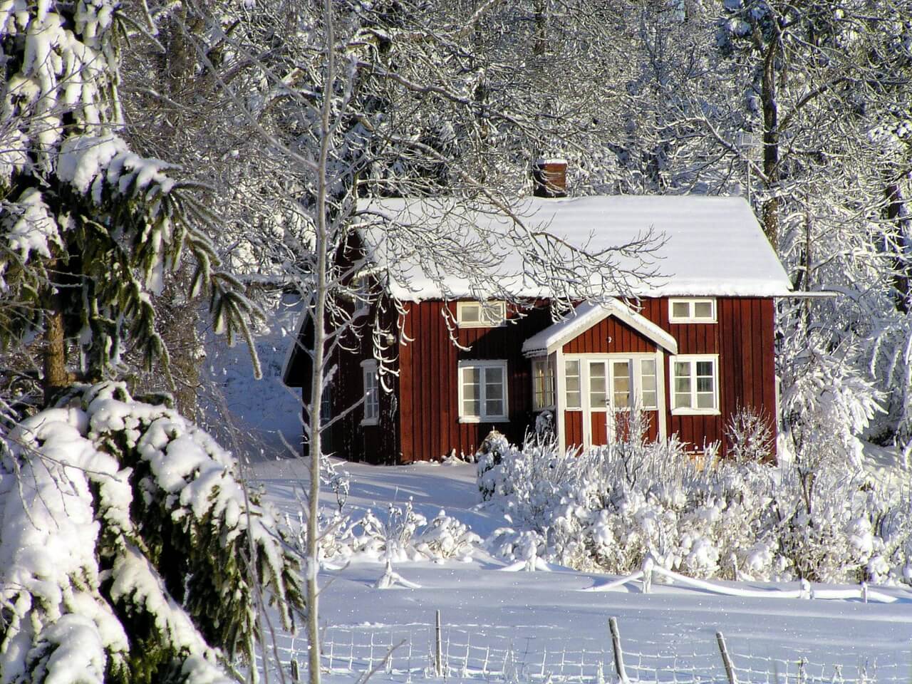 Kuća u šumi prekrivena snegom