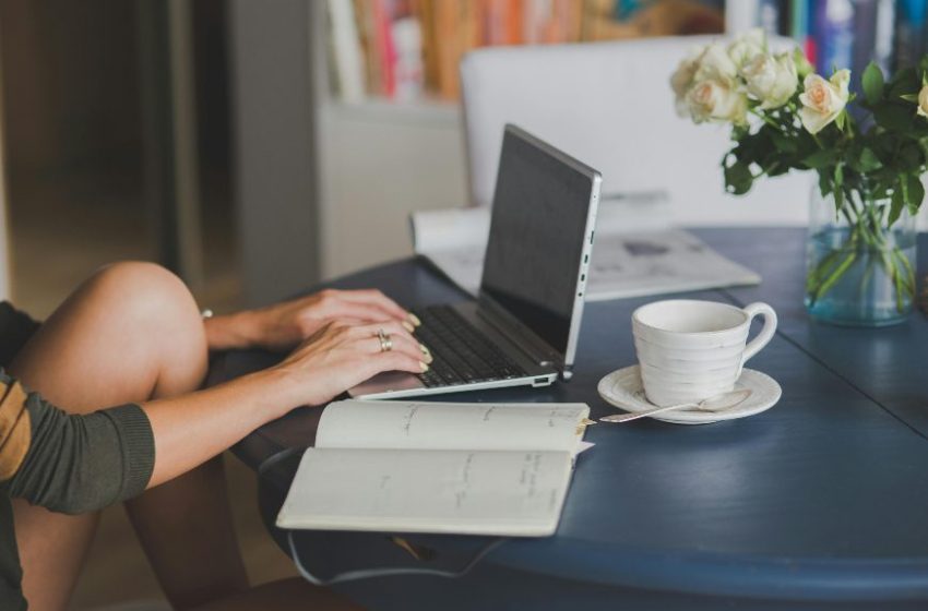 Laptop, notes i šoljica kafe na stolu