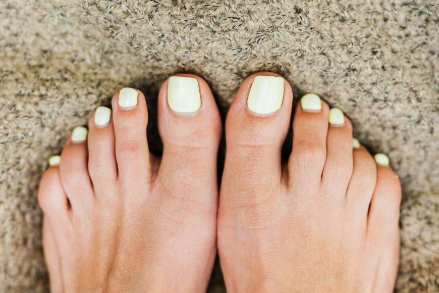 Beli lak na noktima na nogama