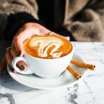 Osoba drži šolju kafe