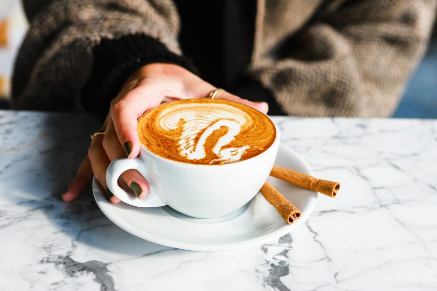 Osoba drži šolju kafe