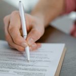 Osoba potpisuje dokument.