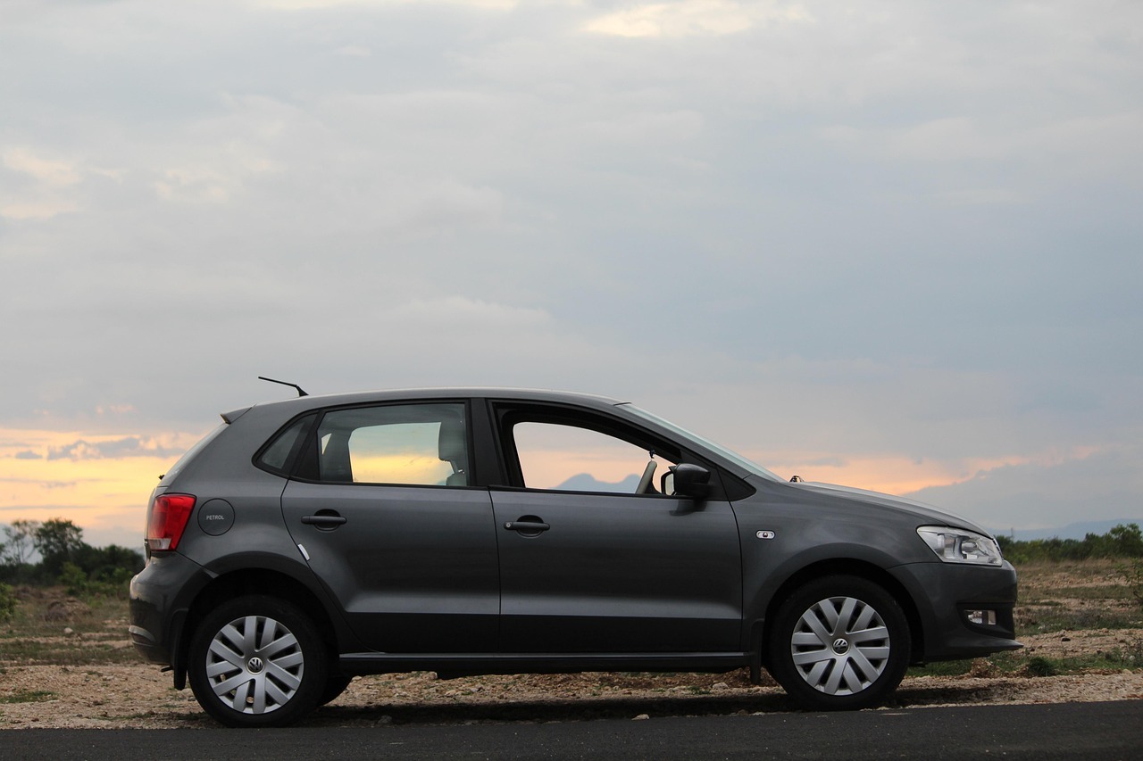 Sivi automobil hečbek parkiran pored puta pri zalasku sunca