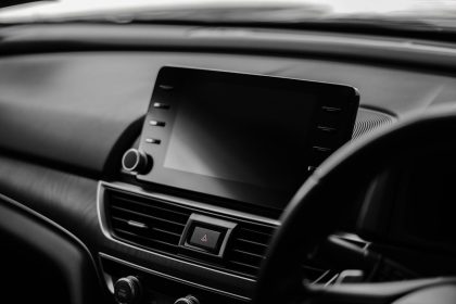 Dodirni ekran na centralnoj konzoli automobila sa ručicom i ventilacionim rešetkama